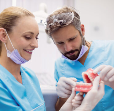 Dentists having discussion on teeth model at dental clinic